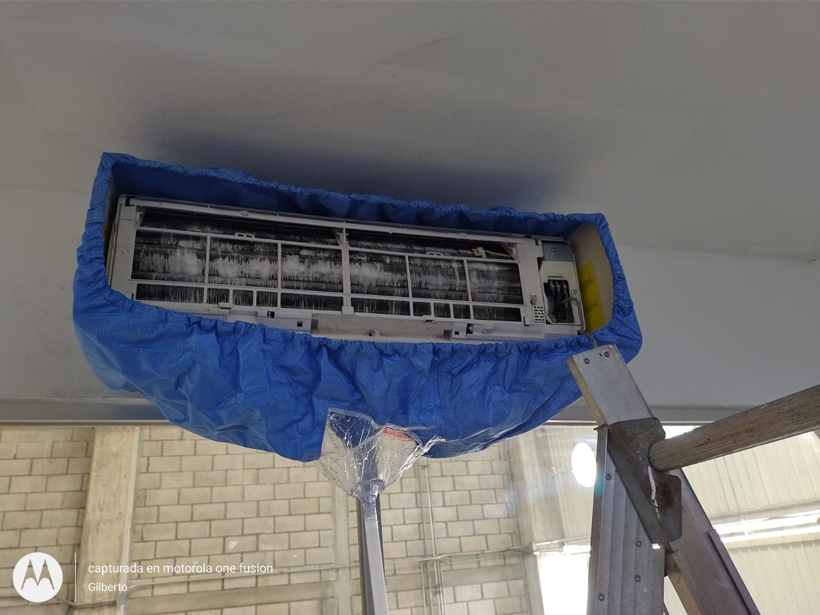 Técnico realizando mantenimiento a una unidad de aire acondicionado tipo minisplit.